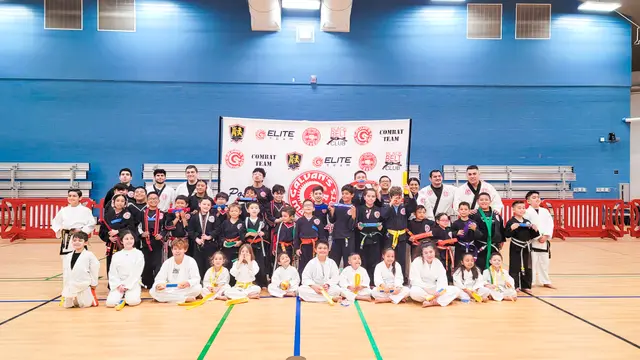 A large group of students and instructors in uniform, lined up in front of the academy banner.